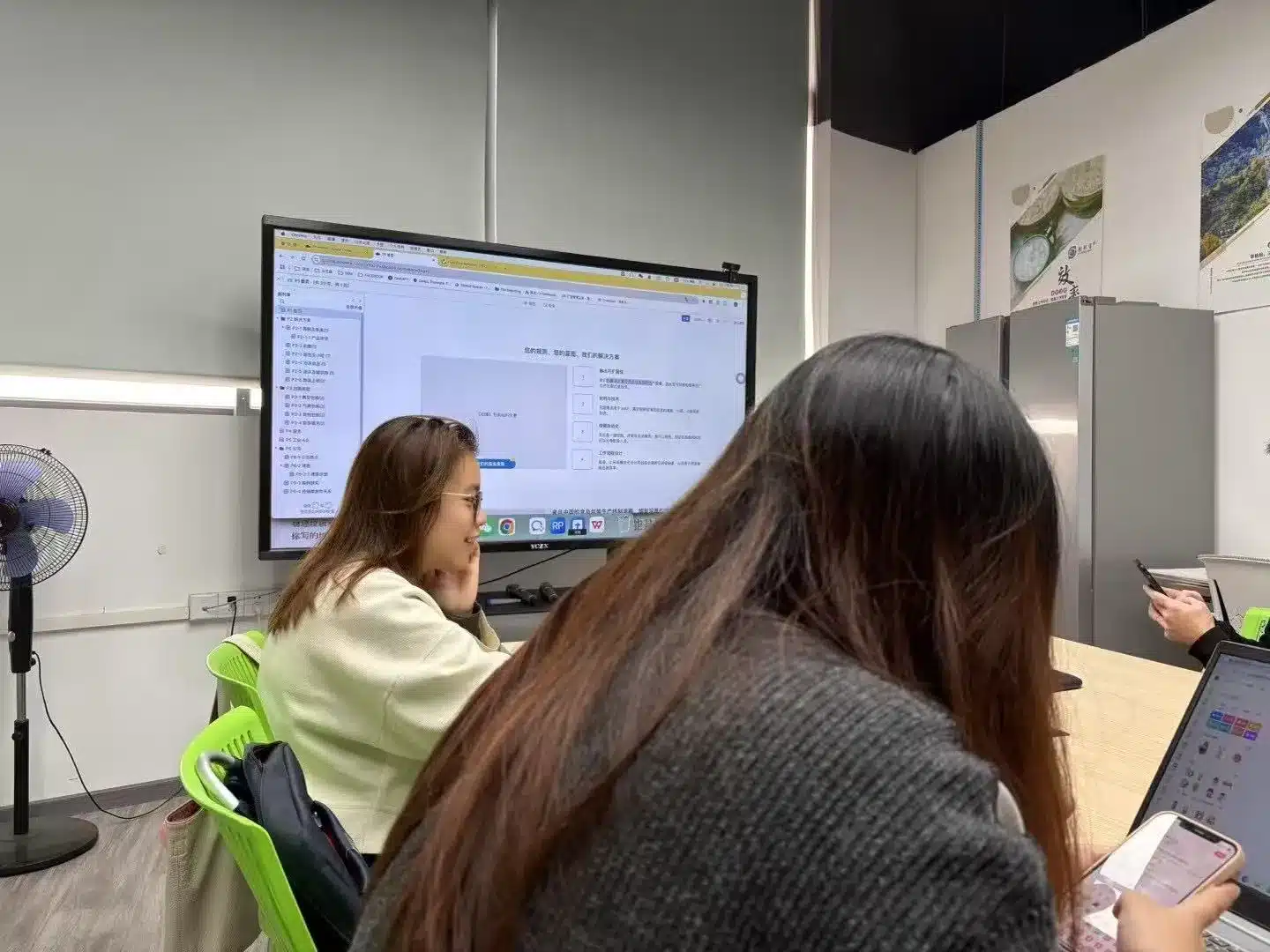 Infility team in a conference room reviews a WordPress site mockup on a large monitor while using laptops and smartphones, demonstrating collaborative planning for 外贸独立站定制开发服务. This scene highlights our focus on high-conversion independent-site design, SEO and Google ad landing optimizations for B2B export clients.