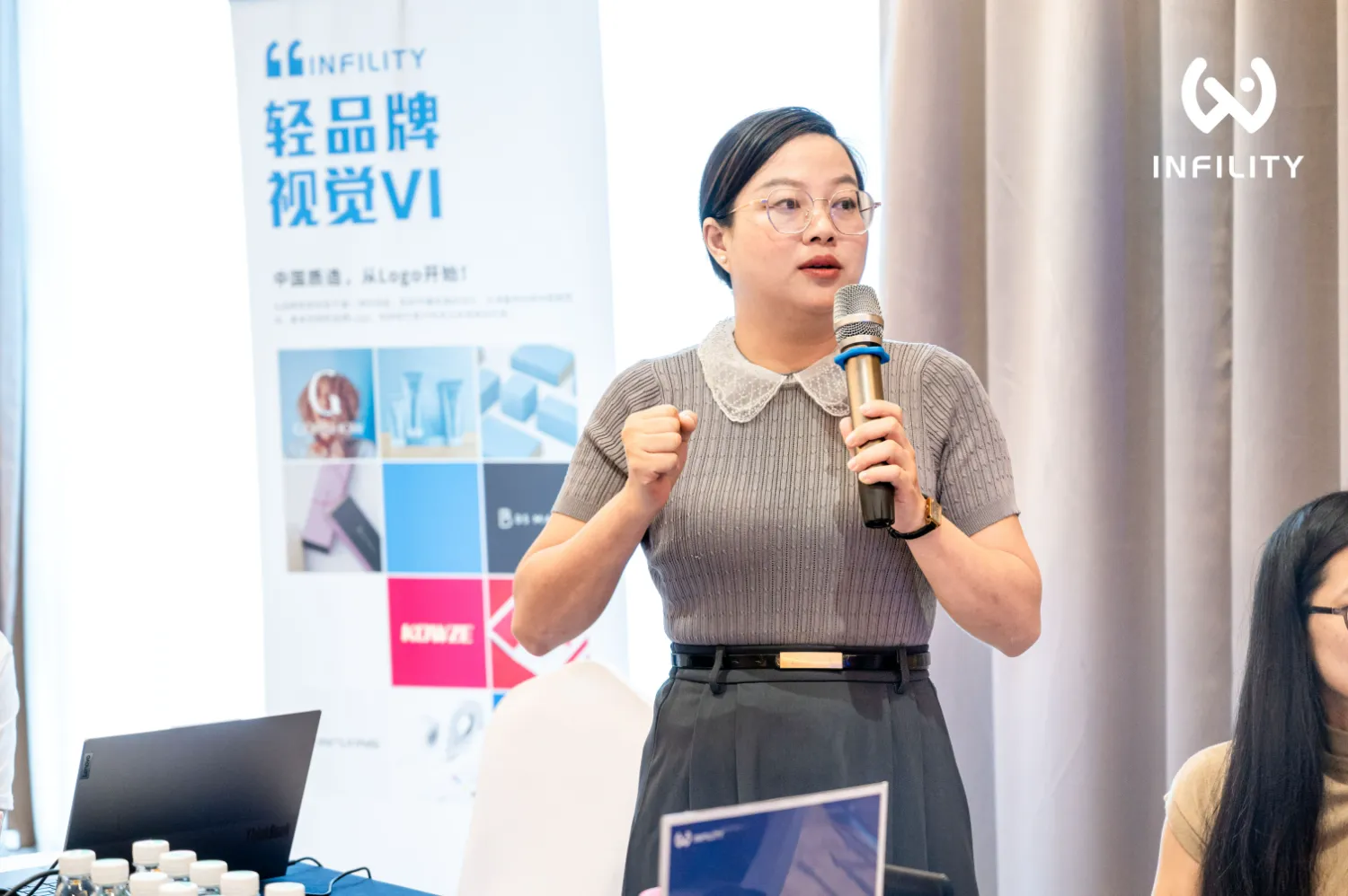 轻品牌视觉 VI 设计分享会现场,演讲者讲解品牌视觉与官网形象的关系