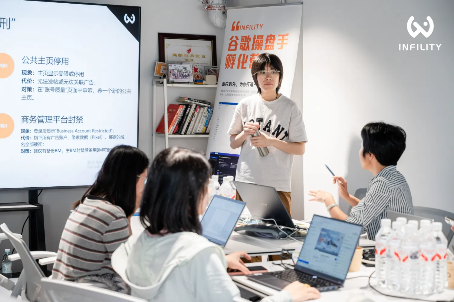 广告优化师在培训现场用笔记本电脑核对谷歌广告转化数据与预算增长曲线